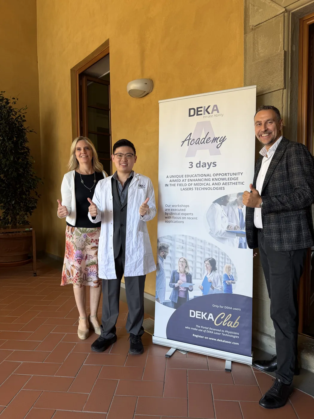 Dr Sin Yong with members of the DEKA team beside the DEKA Academy three-day banner in Florence