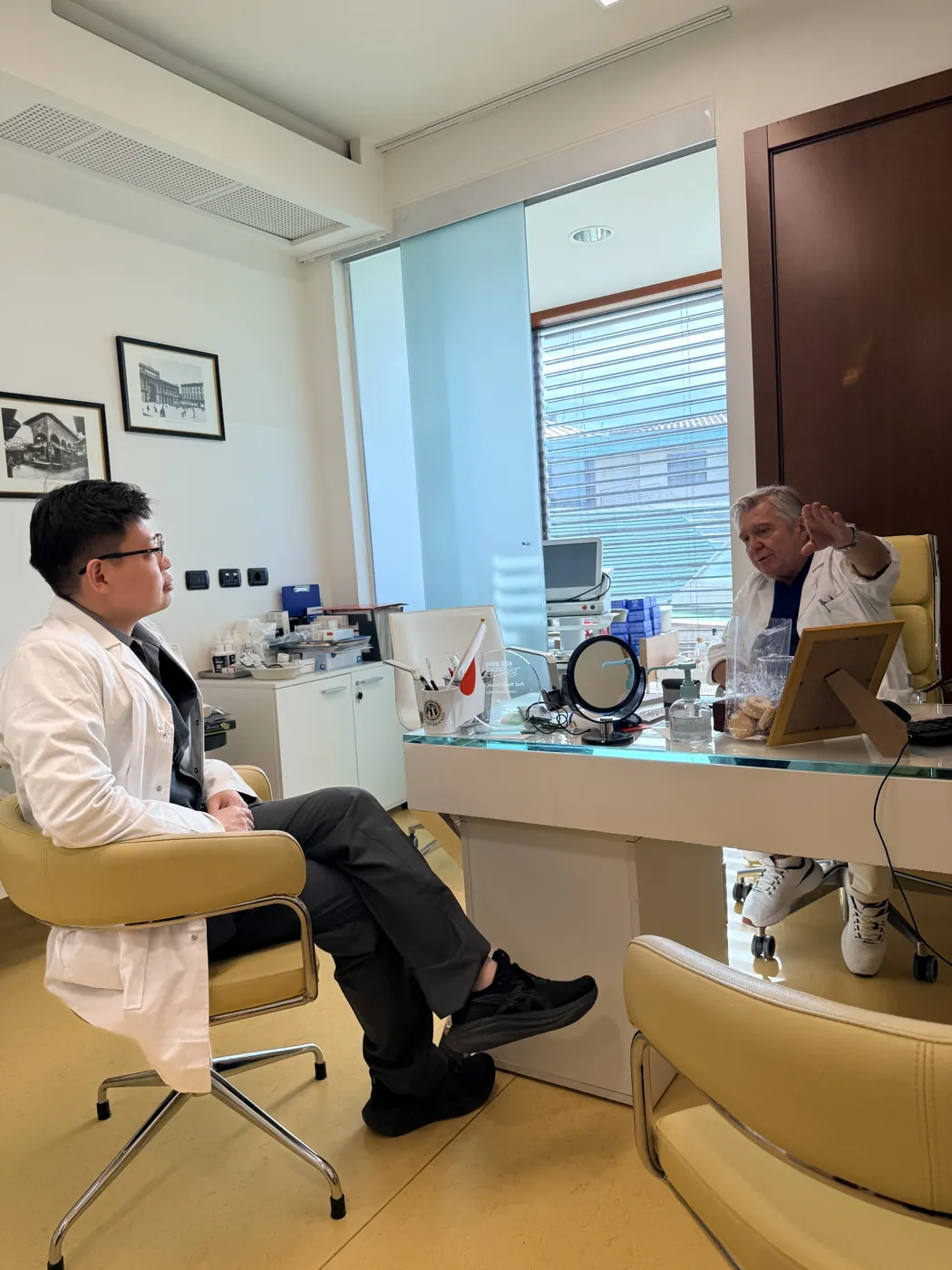 Dr Sin Yong in conversation with Prof Paolo Bonan at his desk in Florence