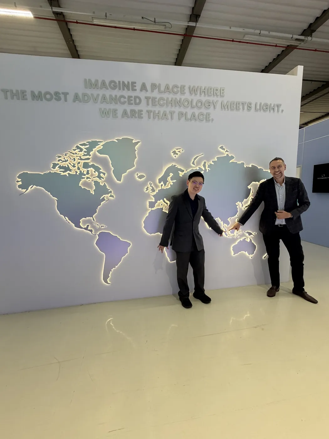 Dr Sin Yong and Francesco Badii pointing at the DEKA world map wall in Calenzano