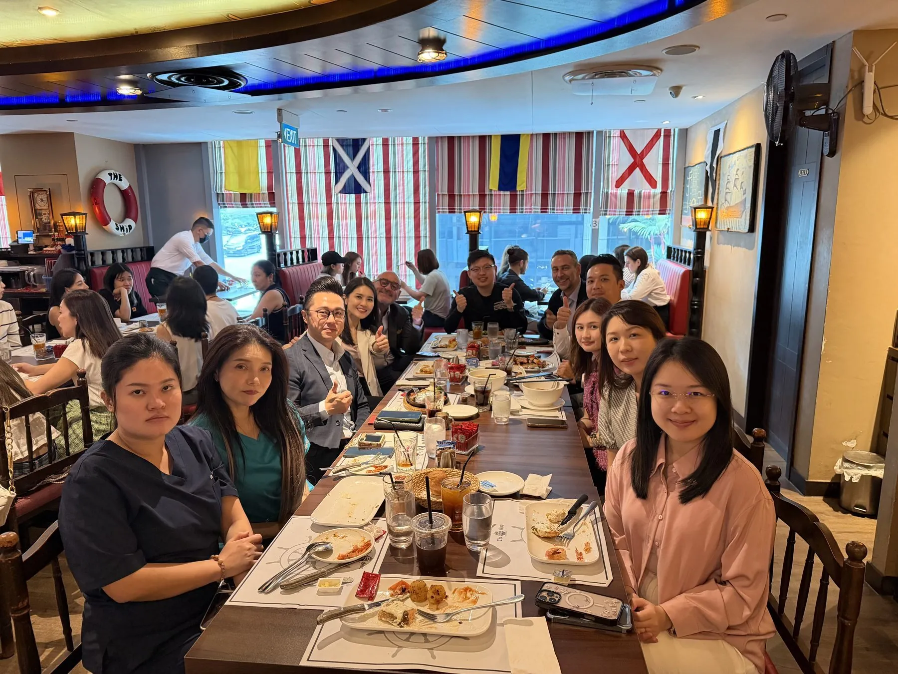The clinic team and DEKA delegation over lunch during the July 2026 clinical exchange in Singapore