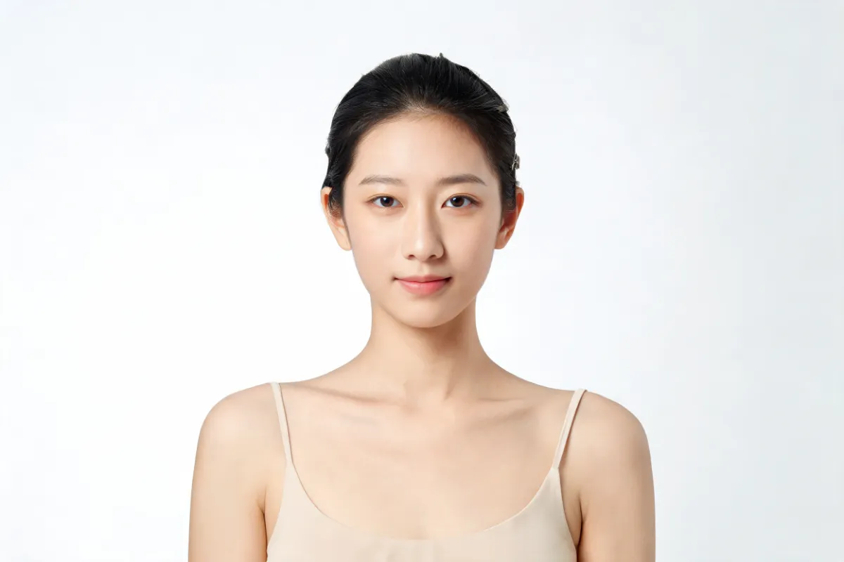 A woman in her twenties with bare skin in soft clean light (illustrative image, not a patient)