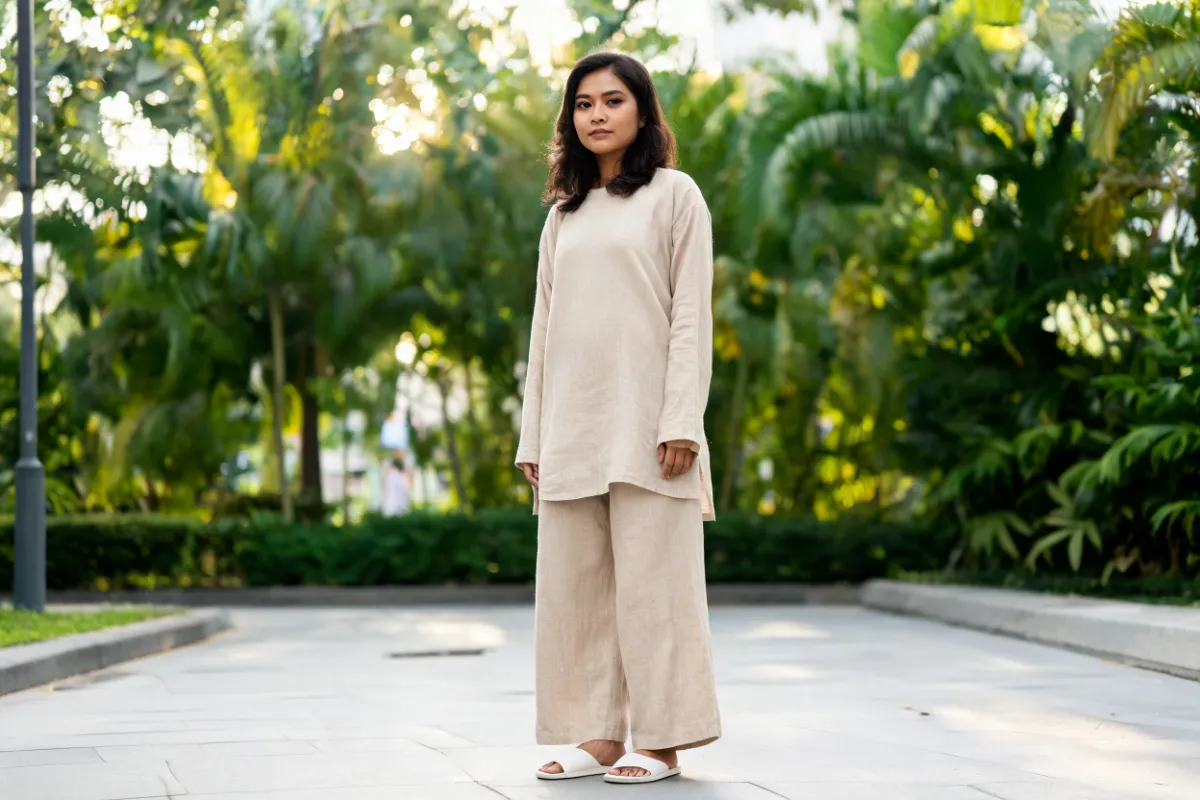 A woman in her thirties standing in daylight in a loose linen set (illustrative image, not a patient)