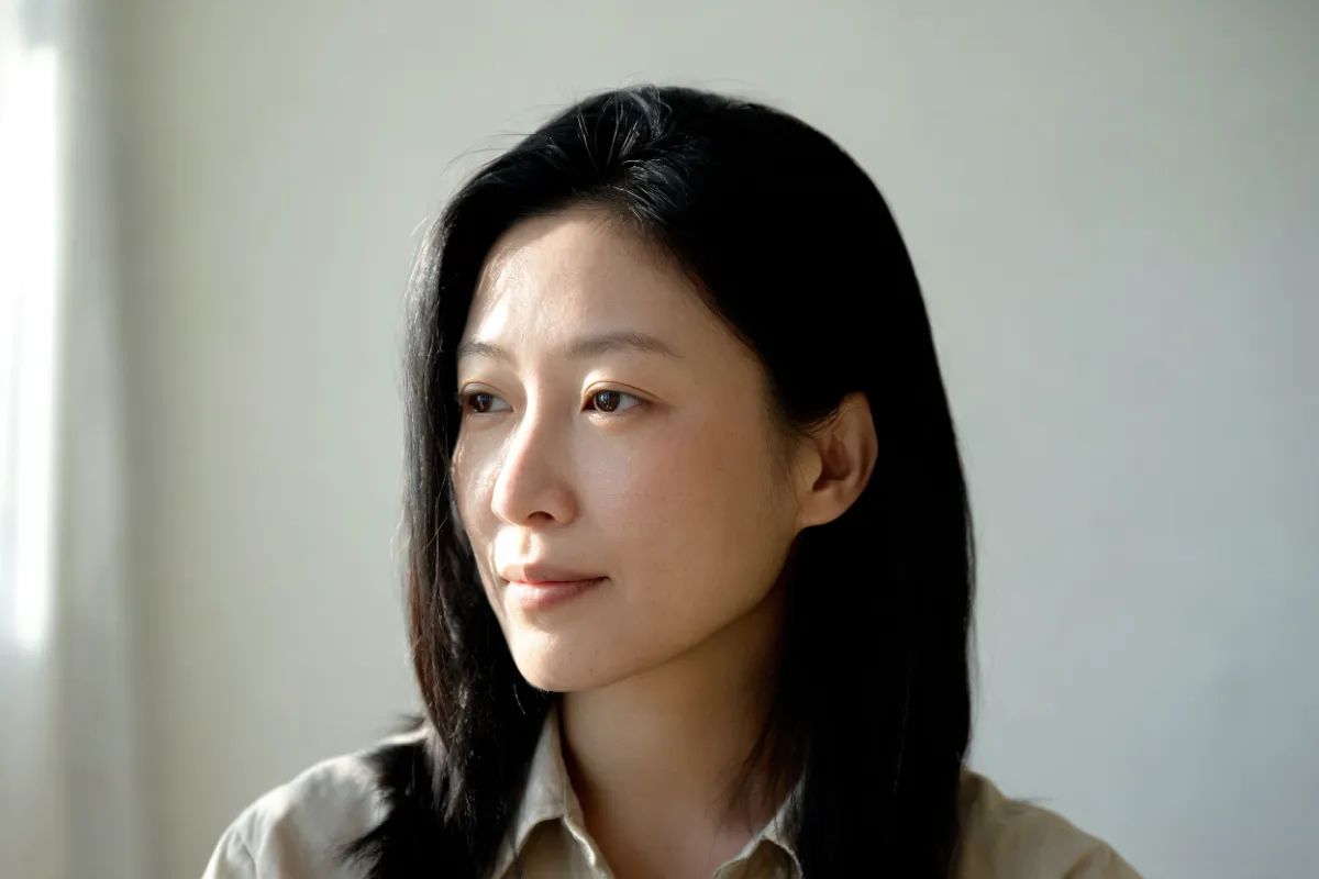 A woman in her thirties with her cheek turned toward the light (illustrative image, not a patient)