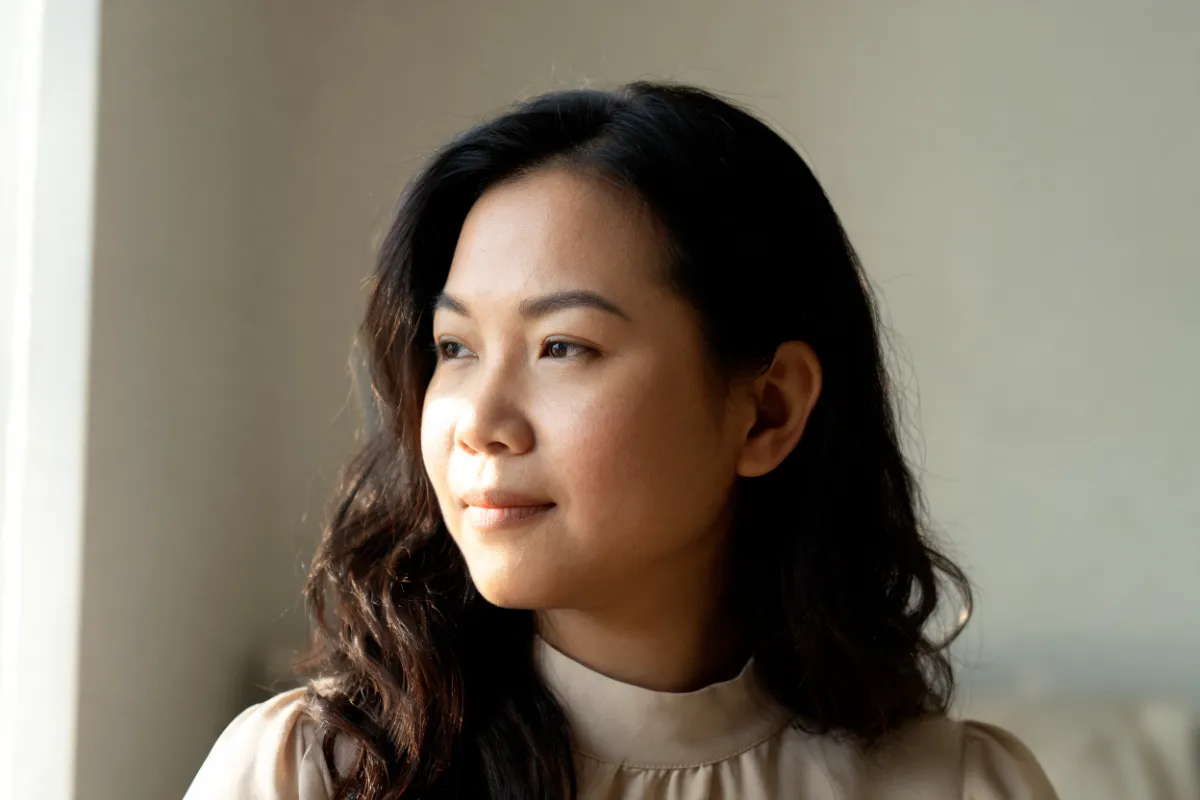 A woman in her thirties with her cheek turned toward the light (illustrative image, not a patient)