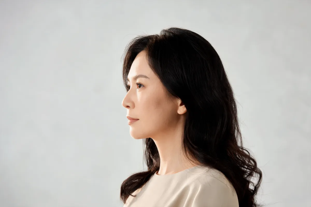 A woman in her thirties in soft profile light (illustrative image, not a patient)