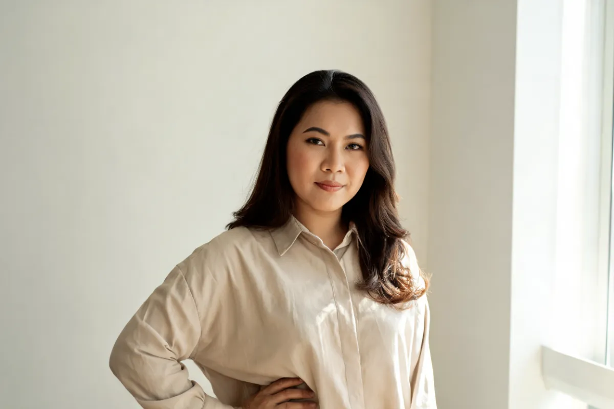 A woman in her thirties in a loose shirt with a hand on her hip (illustrative image, not a patient)