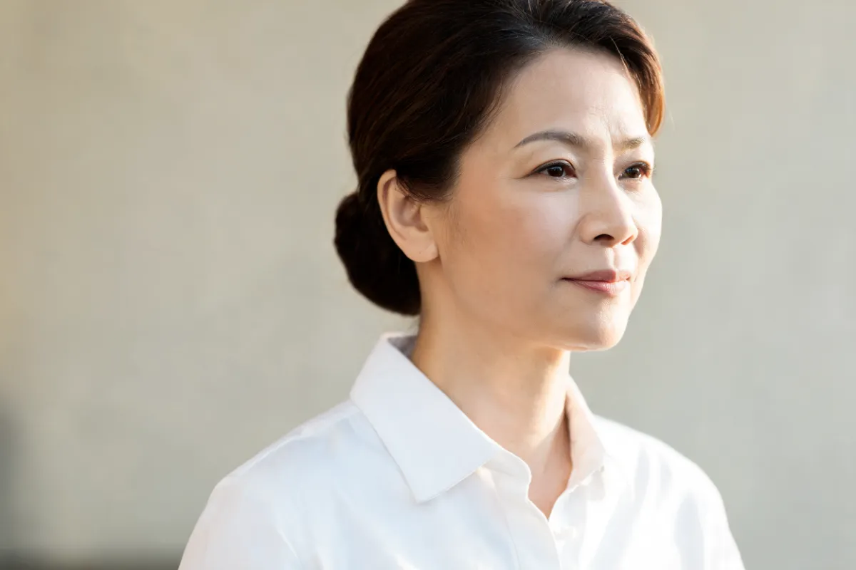 A woman in her forties with her jawline turned toward soft light (illustrative image, not a patient)
