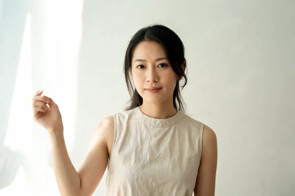 A woman in her thirties in a sleeveless top in daylight (illustrative image, not a patient)