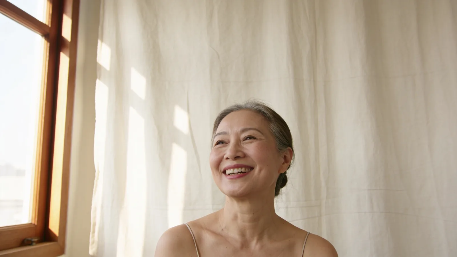 Illustrative model smiling in soft window light — not a patient